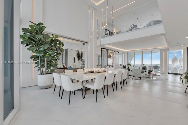 dining room featuring floor to ceiling windows and a towering ceiling