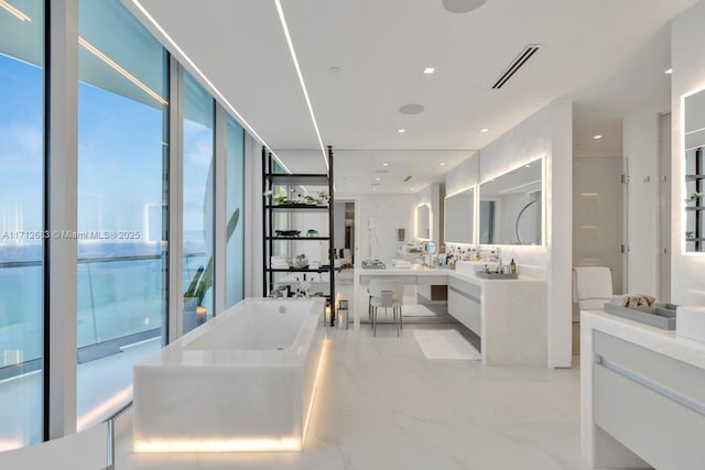 bathroom with vanity, floor to ceiling windows, and a bath