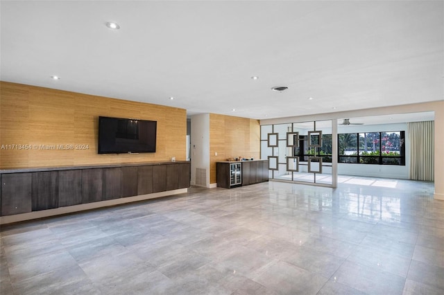 unfurnished living room featuring ceiling fan and beverage cooler