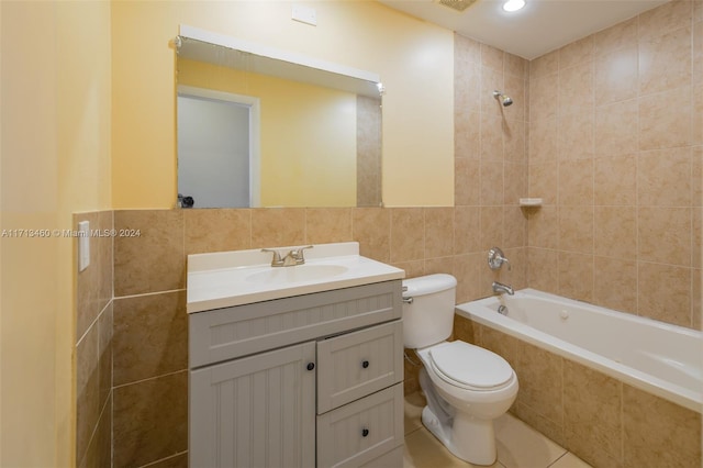 full bathroom with vanity, tiled shower / bath combo, toilet, and tile walls