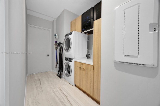 laundry room with cabinets and stacked washer and dryer