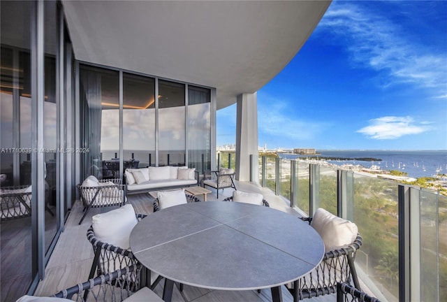 balcony with an outdoor living space and a water view