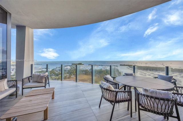 balcony featuring a water view and a view of the beach