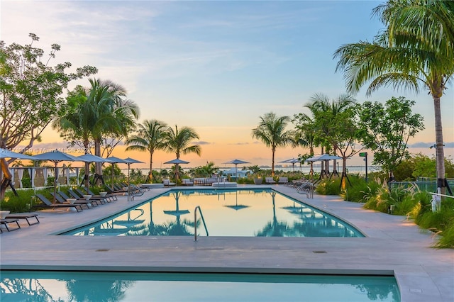 pool at dusk featuring a patio area