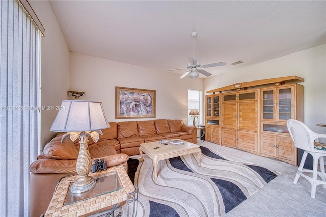 carpeted living room with ceiling fan and a healthy amount of sunlight