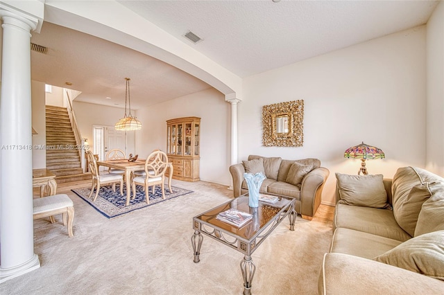 carpeted living room featuring ornate columns