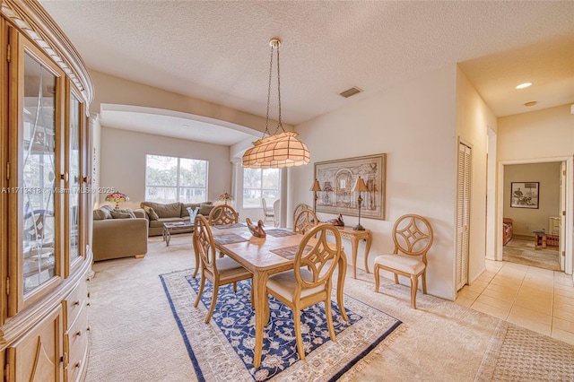 tiled dining space with a textured ceiling