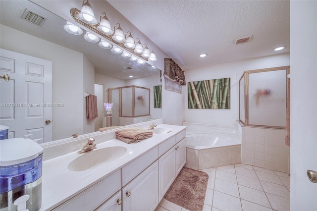 bathroom with tile patterned floors, vanity, a textured ceiling, and shower with separate bathtub