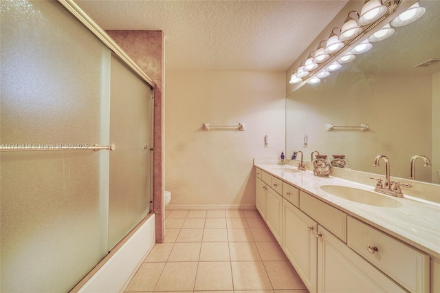 full bathroom with tile patterned flooring, a textured ceiling, combined bath / shower with glass door, toilet, and vanity