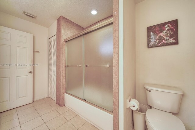 bathroom with tile patterned flooring, vanity, a textured ceiling, and toilet