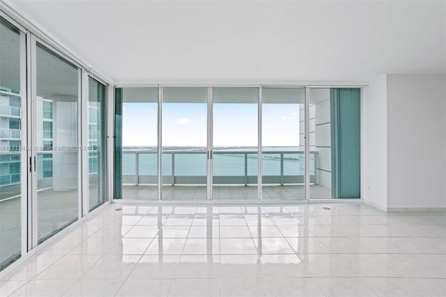 spare room featuring floor to ceiling windows, a wealth of natural light, and light tile patterned flooring