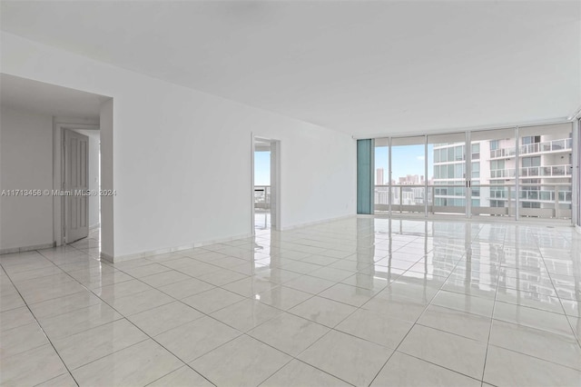 unfurnished room featuring floor to ceiling windows and light tile patterned floors