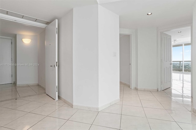 hallway featuring light tile patterned flooring and a wall of windows