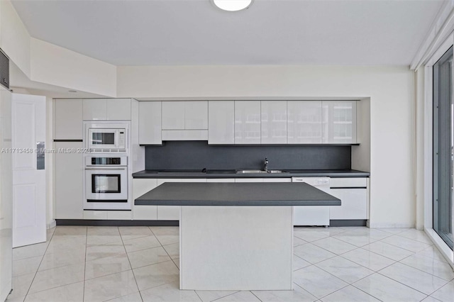 kitchen featuring white appliances, backsplash, white cabinets, sink, and range hood