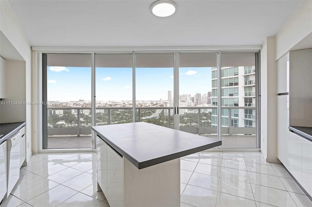 kitchen with white cabinetry, light tile patterned flooring, and a wall of windows