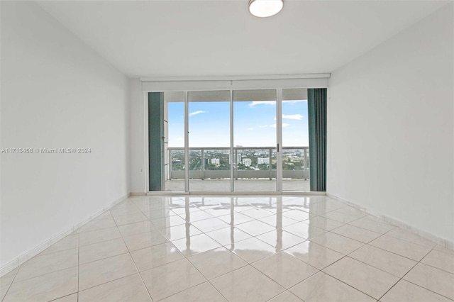 tiled empty room with a wall of windows