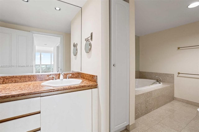 bathroom with vanity, tile patterned floors, and tiled tub