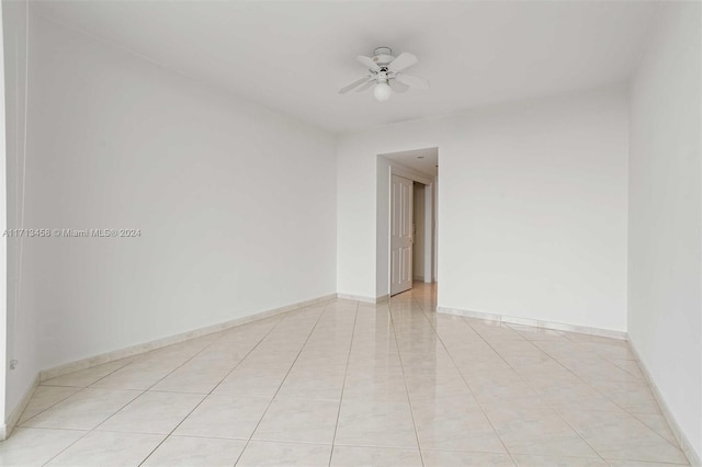 tiled empty room featuring ceiling fan