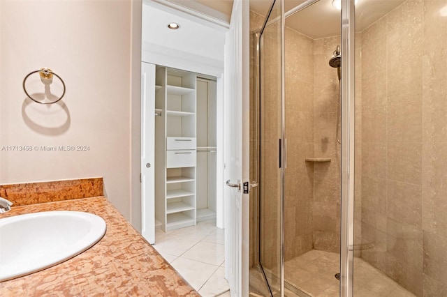 bathroom featuring tile patterned flooring, vanity, and walk in shower