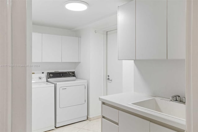 laundry area featuring cabinets, independent washer and dryer, light tile patterned floors, and sink