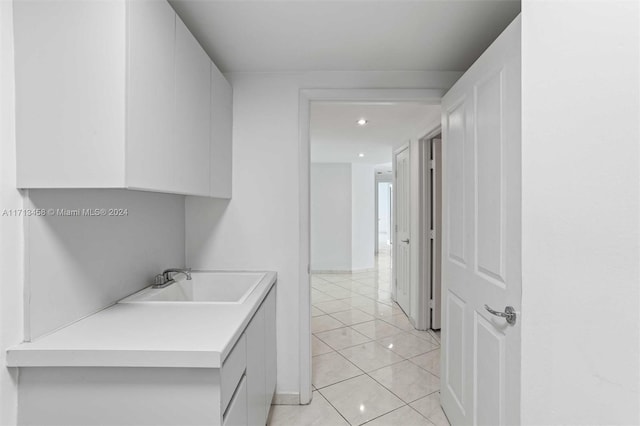 laundry area featuring light tile patterned floors and sink