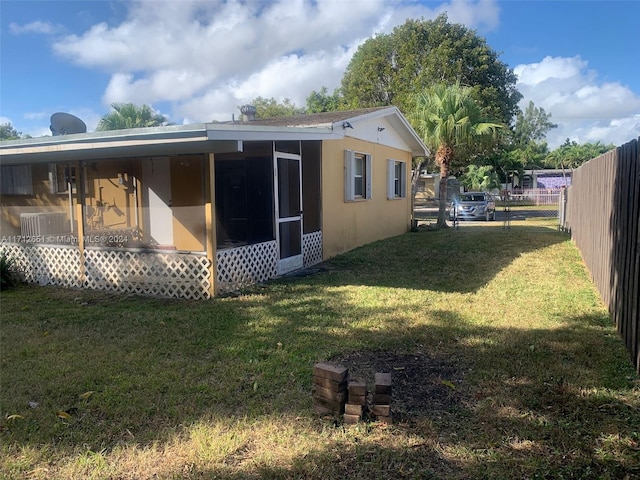 view of property exterior featuring a sunroom and a yard