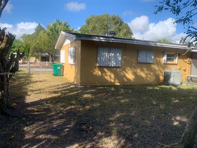 view of side of home featuring a lawn and central air condition unit