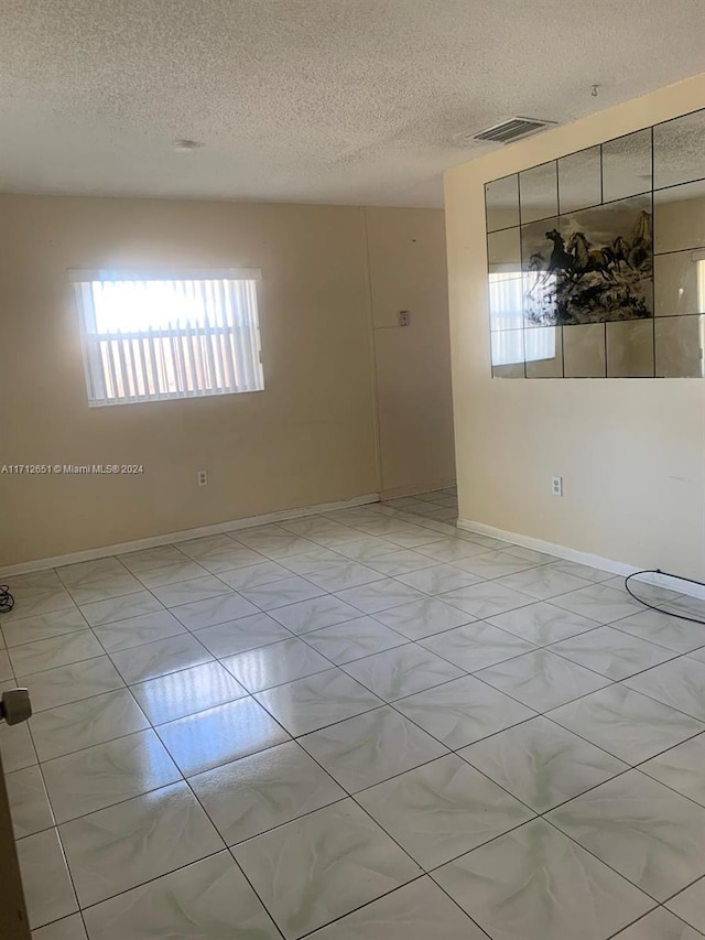 unfurnished room featuring a textured ceiling