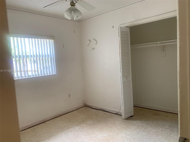 unfurnished bedroom featuring a textured ceiling, a closet, and ceiling fan