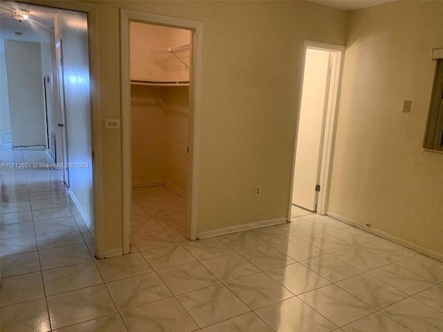 unfurnished bedroom with light tile patterned floors and a closet