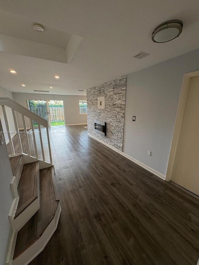 unfurnished living room with a fireplace and dark hardwood / wood-style floors