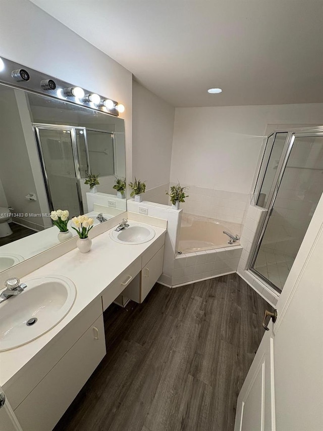 bathroom with plus walk in shower, wood-type flooring, and vanity