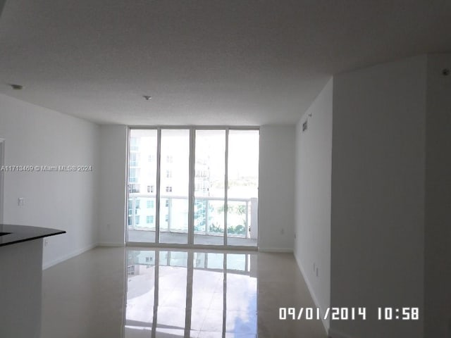 unfurnished room with plenty of natural light and a wall of windows