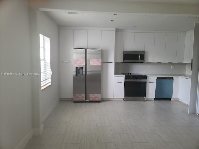 kitchen with decorative backsplash, white cabinetry, and appliances with stainless steel finishes