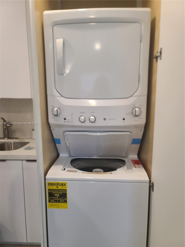 laundry room featuring sink and stacked washing maching and dryer