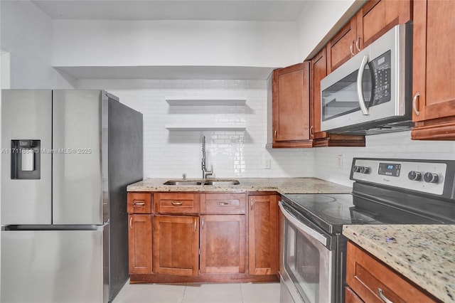 kitchen featuring sink, backsplash, light stone countertops, and appliances with stainless steel finishes