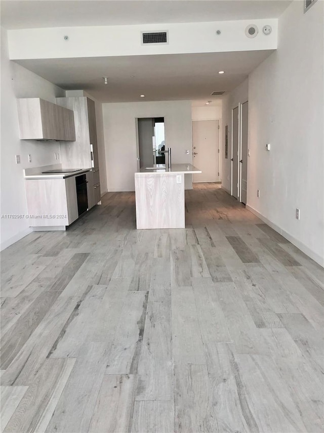 kitchen featuring a kitchen island with sink and light hardwood / wood-style flooring