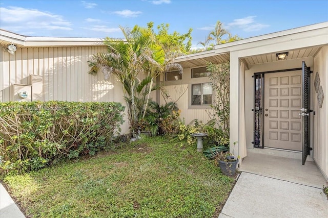 view of exterior entry with a yard