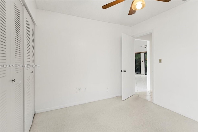 unfurnished bedroom with ceiling fan and a closet