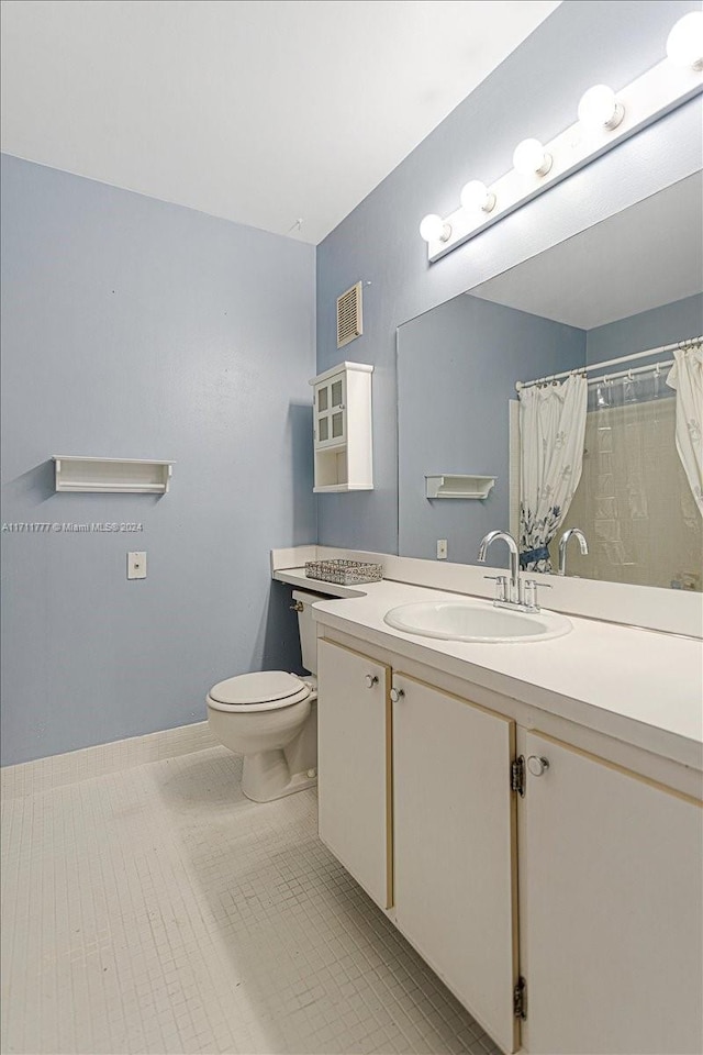 bathroom featuring tile patterned floors, vanity, toilet, and curtained shower