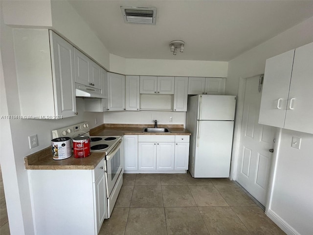 kitchen with white cabinets, white appliances, sink, and light tile patterned floors