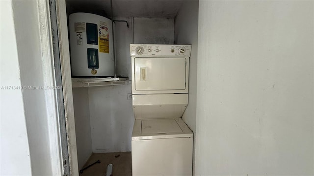 laundry area with stacked washer / dryer and water heater