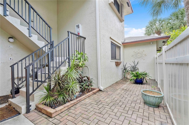 view of patio with stairs and fence