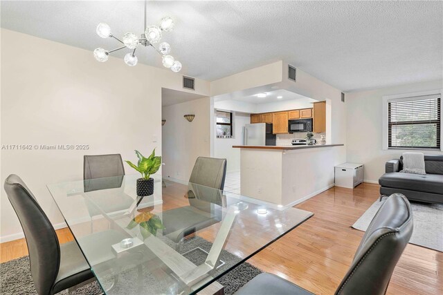 1750 NE 39th Ct Unit 808, Pompano Beach, FL 33064 - dining area featuring light wood-type flooring, baseboards, and a textured ceiling