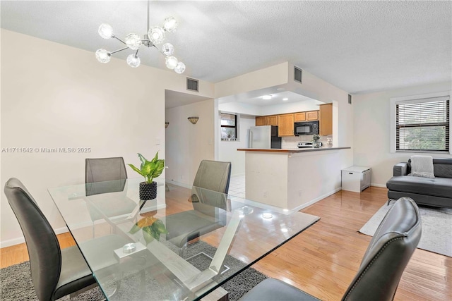 dining space with visible vents and light wood-style flooring