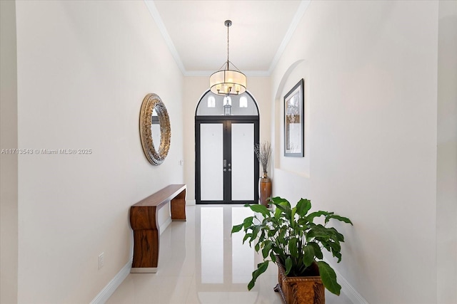 entryway with ornamental molding and an inviting chandelier