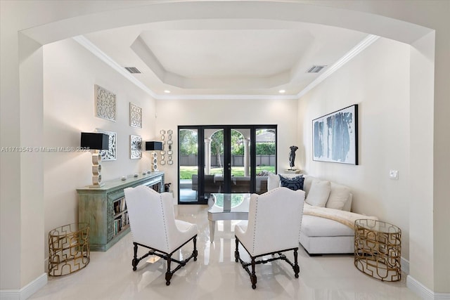 living room featuring ornamental molding, a raised ceiling, and french doors