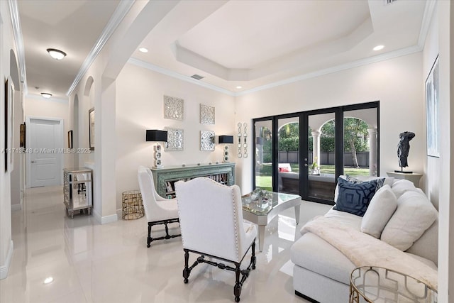 living room featuring a tray ceiling, crown molding, and french doors