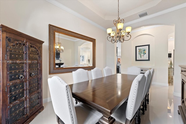 dining area with crown molding, a notable chandelier, and a raised ceiling