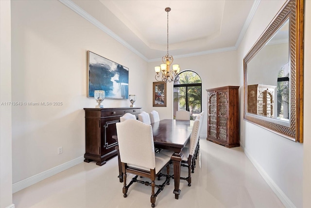 dining area with a chandelier, a tray ceiling, and ornamental molding